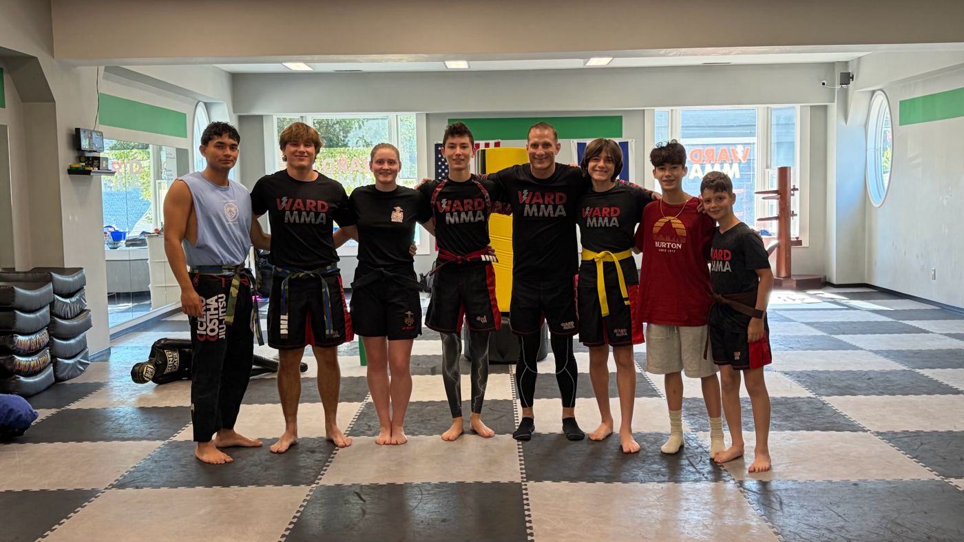 Teen students and Coach Jay on the mats inside the Ward MMA gym
